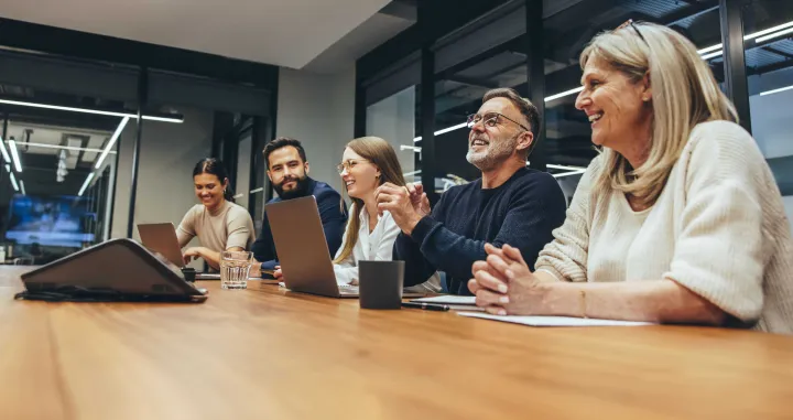 Photo of people around a conference table talking